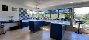 a large kitchen with blue cabinets and windows at Misty River in Macksville