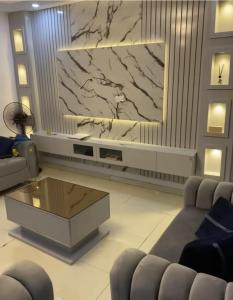 a living room with a large television and a coffee table at Karachi Family Guest House in Karachi