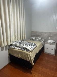 a bed in a room with a window at Apartamento espaçoso para locação - Bairro Universitário in Bento Gonçalves