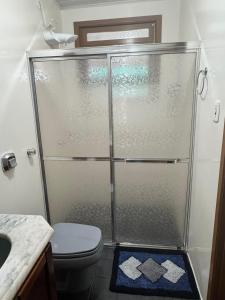 a bathroom with a shower with a toilet and a sink at Apartamento espaçoso para locação - Bairro Universitário in Bento Gonçalves