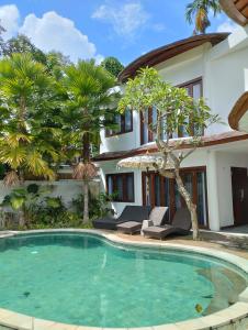 a swimming pool in front of a house at 3 Bedroom Gadang Villa Ubud in Ubud
