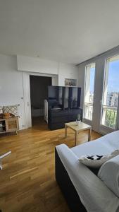 sala de estar con cama y TV de pantalla plana en Paris 16eme vista a la torre eiffel, en Boulogne-Billancourt