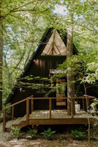 a tree house in the woods with a deck at Wilewood A-Frame, Romantic Treehouse Getaway, Hot Tub in Abbeville