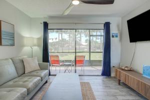 a living room with a couch and a flat screen tv at Ocean Side Complex with Heated Pool B-15 in Saint Augustine