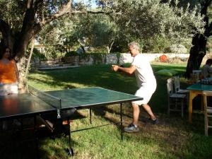 a man playing ping pong on a ping pong table at Emel Pension in Güzelçamlı