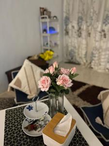 a table with a vase with pink roses on it at Rumah Inap Wancu formuslim in Gambang +20 photos