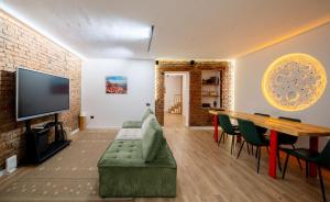 a living room with a couch and a table and a tv at Niabi Villa with pool in Tbilisi City