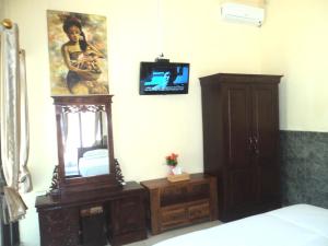 a bedroom with a mirror and a tv on a wall at Villa Green House in Nusa Penida