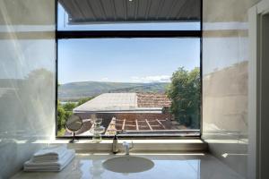a bathroom with a sink and a large window at Niabi Villa with pool in Tbilisi City