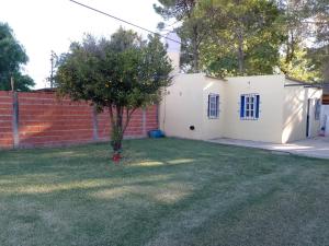 a small white house with a tree in the yard at Patio Escondido in Paraná