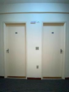three white doors on a wall in a room at LN Flats & Suites in Uberlândia +122 photos