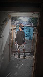 a man standing in a doorway with a painting on the wall at Yeiko in Carlos Guerra
