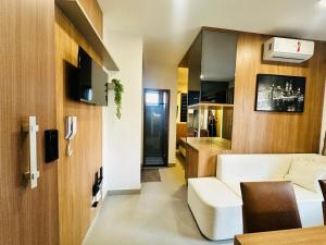 a small apartment with a white couch and a kitchen at Loft exclusive a 200 metros da Ufu in Uberlândia
