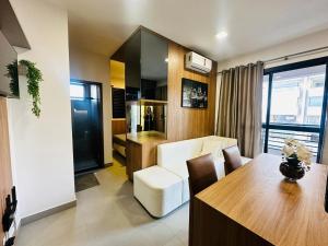 a living room with a couch and a table in a room at Loft exclusive a 200 metros da Ufu in Uberlândia