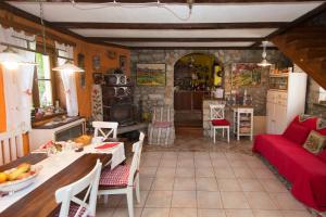 a kitchen and a living room with a red couch at Rozina Vacation House in Pliskovica