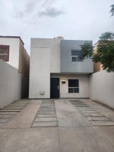 a white building with a door and a courtyard at Casa Cálida in La Coyotera