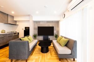 a living room with two couches and a tv at Amp Flat TFK西新駅前 in Fukuoka