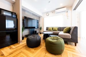a living room with a couch and two bean bags at Amp Flat TFK西新駅前 in Fukuoka