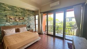 ジンバランにあるBukawa Lodge Jimbaranのベッドとバルコニーのある寝室 +82枚の写真