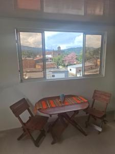 a table and two chairs in a room with a window at Penthouse - Altos de Iguaque in Gámbita