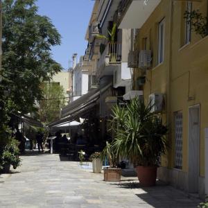 a street in a city with buildings and plants at Athens Plaka Acropolis Suites in Athens