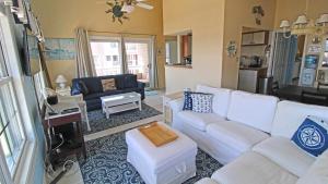 Una sala de estar con un sofá blanco y una mesa. en Capers Unit 803, en Cape May