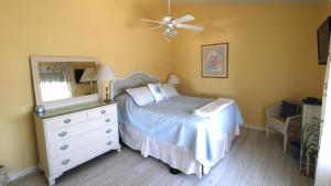 1 dormitorio con 1 cama, vestidor y ventilador de techo en Capers Unit 803, en Cape May