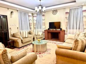 a large living room with couches and a television at N1 house St Helen lane Karen in Nairobi