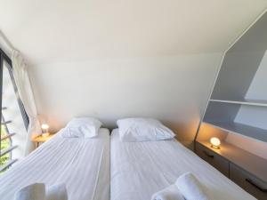 a small bedroom with two beds and a window at Holiday home Waterland for six Person in Egmond aan den Hoef