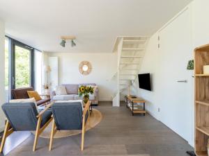 a living room with a couch and a staircase at Holiday home Waterland for six Person in Egmond aan den Hoef