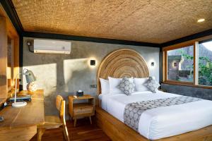 a bedroom with a bed and a desk and a bed sidx sidx sidx at Lorel Green Domain Ubud in Ubud