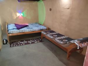 a small room with two bunk beds and a table at Natural mudhouse in Kanthalloor