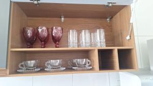 a wooden cabinet with glasses and plates on it at A quiet place close to beach in Barra dos Coqueiros