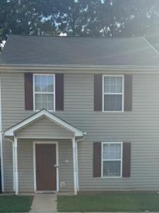 a house with a brown door and three windows at Stockbridge South of Atlanta - Private Room 2 in Stockbridge