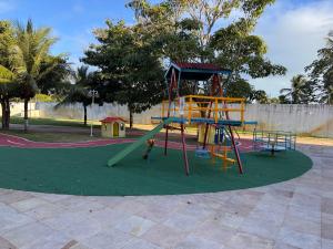 a playground with a slide in a park at A quiet place close to beach in Barra dos Coqueiros