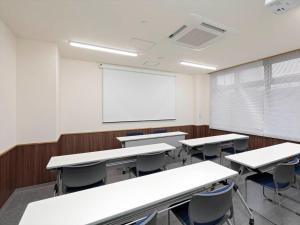 an empty classroom with tables and chairs and a whiteboard at A&Bee HOTEL in Oita