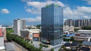 a tall glass building in a city with buildings at Holiday Inn Express Foshan Sanshui by IHG in Foshan