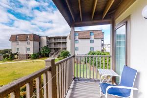 a balcony with a blue chair and a view of a building at Southwinds I1 in Atlantic Beach