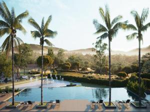 a pool with chairs and palm trees in a resort at Pyreneus Residence in Pirenópolis +15 photos