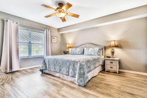Un dormitorio con una cama y un ventilador de techo. en Oceanside 203, en Clearwater Beach