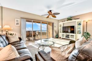 Una sala de estar con un sofá y una mesa de cristal. en Oceanside 203, en Clearwater Beach