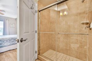Un baño con ducha con puerta de cristal. en Oceanside 203, en Clearwater Beach 19 fotos más