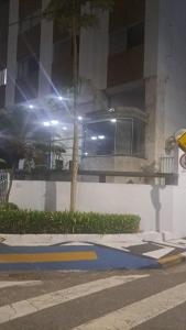 ein Gebäude mit einem Baum am Straßenrand in der Unterkunft Apto a 25 metros areia PITANGUEIRAS Vista mar 4 quartos 3 banheiros 1 vaga carro Serviço de praia in Guarujá