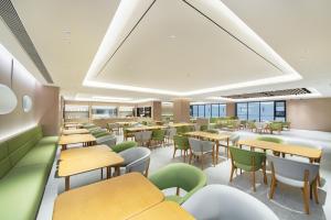 a cafeteria with tables and chairs and windows at JI Hotel Beijing Yizhuang Rongchang West Street in Beijing