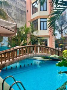 a bridge over a large blue swimming pool with a building at Hotel San Isidro in Malacatán