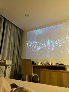 a room with a large projection screen in a hotel room at Emirlan Homestay in Hue