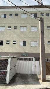 a building with a garage door in front of it at Studio Cyar 44 - Ar-condicionado e Conforto in Taubaté