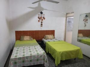 una habitación con dos camas con sábanas verdes en Casa Rokah, en Lázaro Cárdenas