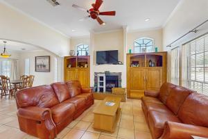 a living room with leather furniture and a ceiling fan at Pelican Pete in Corpus Christi