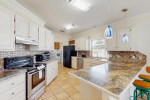 a kitchen with white cabinets and granite counter tops at Pelican Pete in Corpus Christi